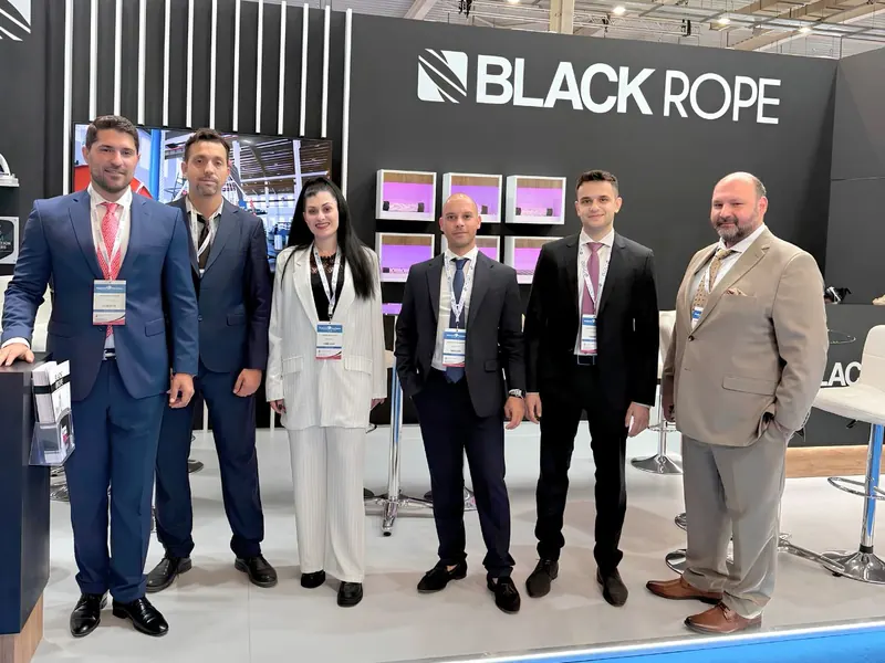 A group of six people standing at a Black Rope exhibition stand.
